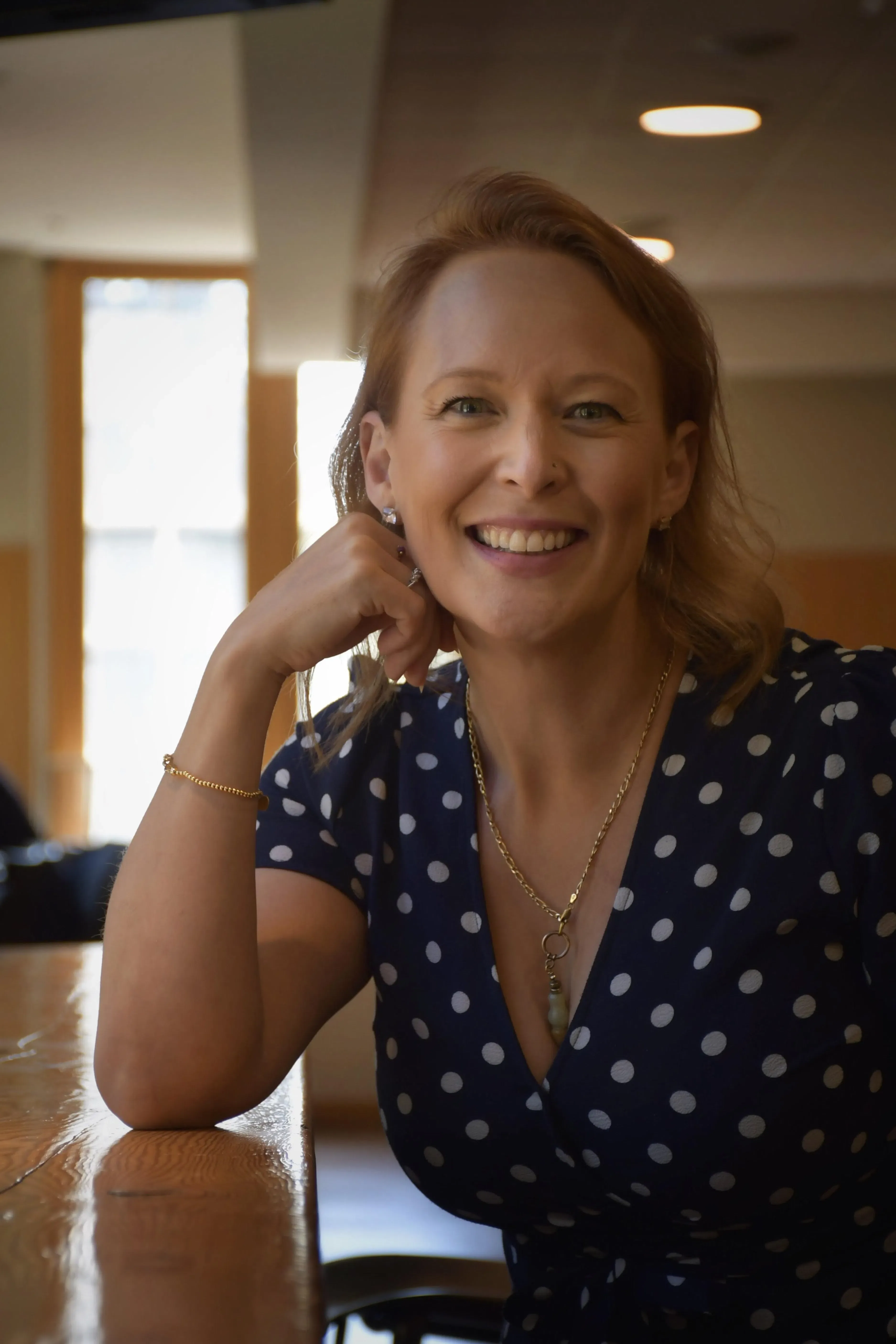 Shelley Doyle smiling at her desk in a bright workspace